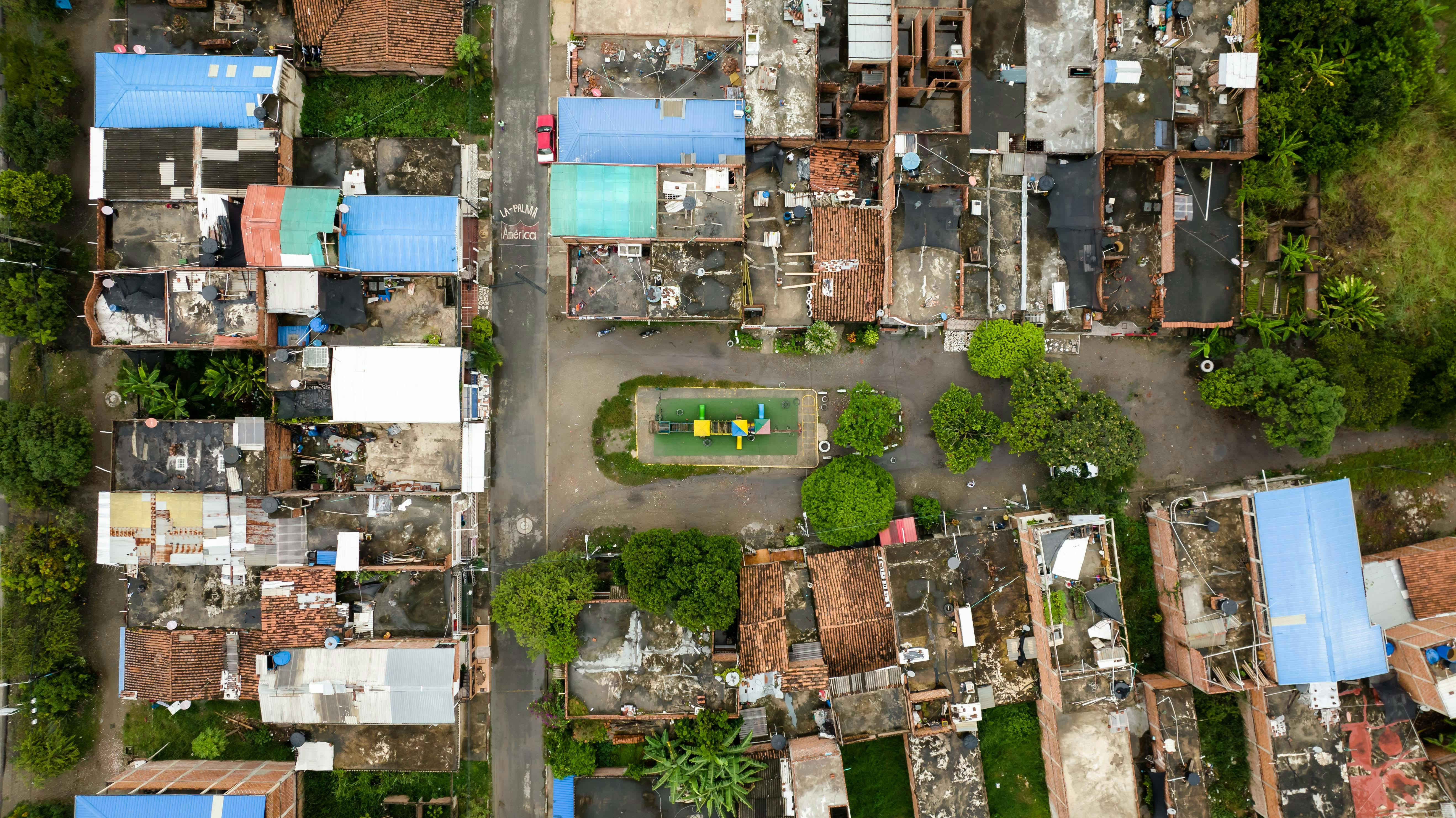 A top-down view of a densely packed suburban neighborhood with roads and greenery.